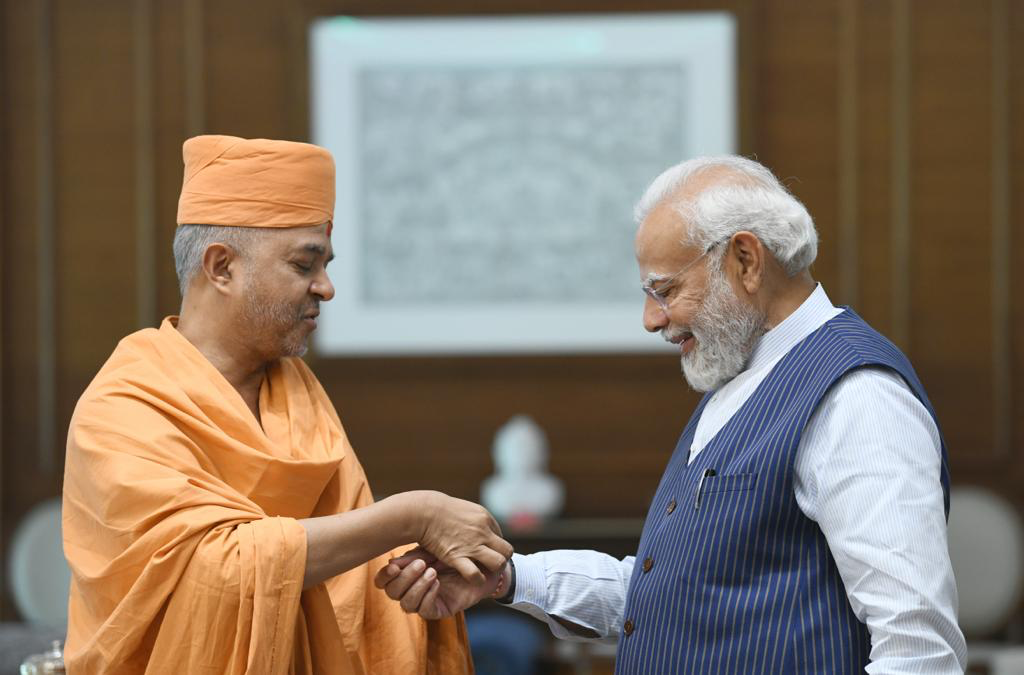 Swami Brahmaviharidas (L) presents prime minister Narendra Modi a copy of the book "In Love, At Ease: Everyday Spirituality with Pramukh Swami" in New Delhi on Friday, March 4, 2023.