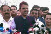 Maharashtra deputy chief minister Devendra Fadnavis (C) speaks to reporters