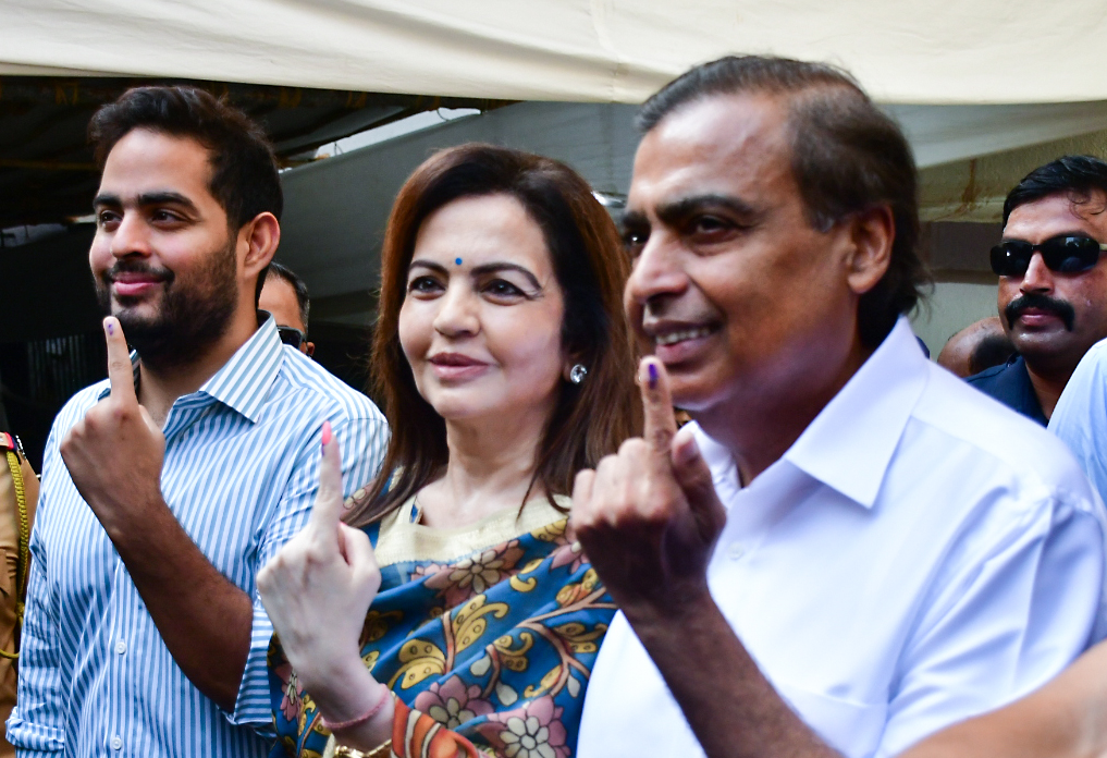 Indian industrialist Mukesh Ambani, his wife Nita Ambani and son Akash Ambani show their fingers after casting ballots in India's national elections 2024