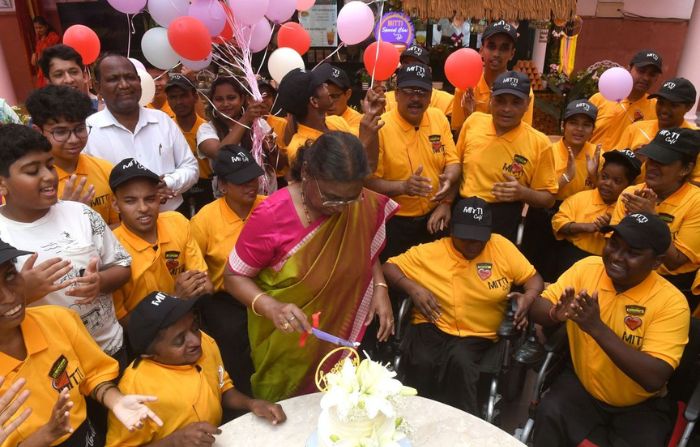 Indian president Droupadi Murmu cuts a cake with the employees of Mitti Cafe, which is run by people with special abilities, at Rashtrapati Bhavan in New Delhi